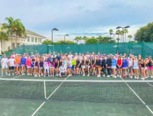 A group of people standing on top of a tennis court.