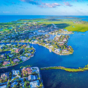 A view of the water from above shows houses, roads and land.