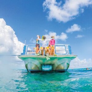 A family is standing on the back of a boat in the ocean.